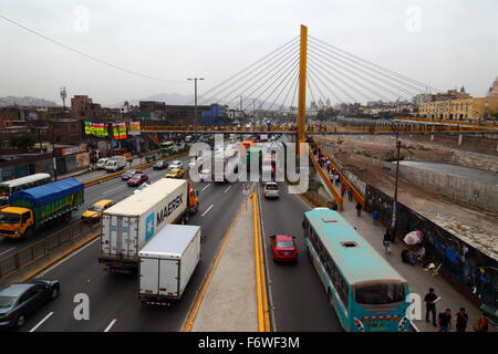 Camions et trafic occupé sur l'autoroute AV Panamericana Norte à côté de la rivière Rimac et Puente Rayito de sol passerelle dans le centre de Lima, Pérou Banque D'Images