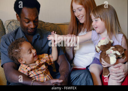 Groupe Famille multiraciale assis ensemble sur le canapé, Banque D'Images