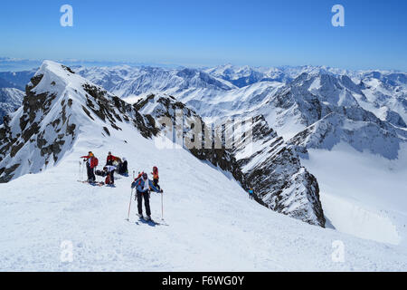 Groupe de personnes ski debout dans l'encoche en face du sommet de Weisskugel, Weisskugel, gamme de Oetztal, Ty du Sud Banque D'Images