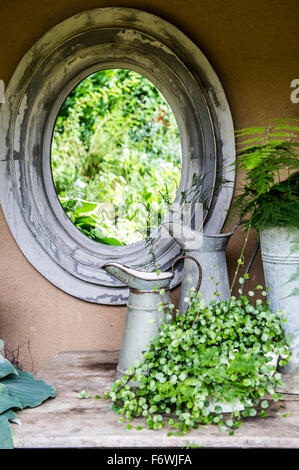 Jardin nature morte au miroir antique et les contenants de lait, Freiburg, Emmendingen, Bade-Wurtemberg, Allemagne Banque D'Images