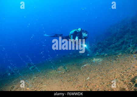 Scuba Diver et bulles de gaz de volcan sous-marin, sable rouge, Pura, Alor, l'Indonésie, Sawu, Pantarstrait la Mer, Océan Indien Banque D'Images
