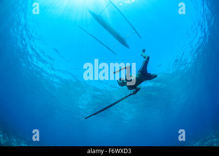 Pêcheur lance local avec outrigger bateau, Alor archipel, l'Indonésie, Sawu, Pantarstrait la Mer, Océan Indien Banque D'Images