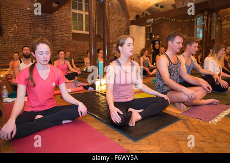 Classe de yoga aux chandelles, dans le centre de Londres, Angleterre, RU Banque D'Images