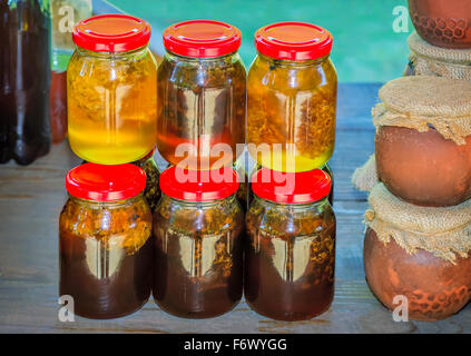 Miel Frais de différentes variétés dans des bocaux en verre avec couvercles à vendre à la foire. Banque D'Images