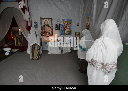 Calais, en Grèce. 20 Nov, 2015. Les femmes, qui ont leurs cheveux couverts en tête traditionnels foulards, prier dans l'Eglise orthodoxe Tewahedo d dans la nouvelle jungle camp de réfugiés. Plus de 6 000 personnes vivent dans des camps de réfugiés de faire à la périphérie de la ville de Calais. Les gens sont sur leur chemin vers la Grande Bretagne, mais ils sont empêchés de s'y rendre en raison de la haute sécurité dans le tunnel sous la Manche. © Michael Debets/Pacific Press/Alamy Live News Banque D'Images