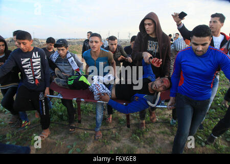 Gaza, la Palestine. 20 Nov, 2015. Un manifestant palestinien blessé porté par ses collègues au cours d'un affrontement avec les troupes israéliennes le long de la frontière dans la banlieue est de la ville de Gaza © Mohamed Zaanoun/Pacific Press/Alamy Live News Banque D'Images