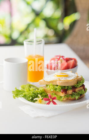 Petit-déjeuner sain avec jeu de sandwich œuf et salade de fruits ainsi que du café et du jus d'orange Banque D'Images