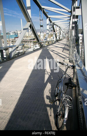 Le vélo garé sur le pont de la botte pour piétons mène au-dessus de la Marina Port Forum à Barcelone Banque D'Images