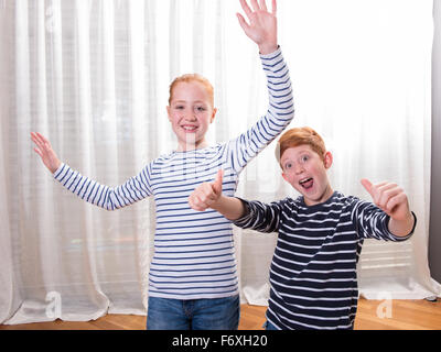 Frère et soeur sourire et forme avec leurs mains Banque D'Images