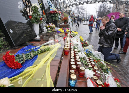 Kiev, Ukraine. 21 Nov, 2015. Un homme prier devant le mémorial aux victimes de manifestations anti-gouvernementales sur Maidan dans la rue Institutska, pendant le deuxième anniversaire de la révolution d'Euromaidan à Kiev, Ukraine, le 21 novembre 2015. Le 21 novembre 2013 a commencé des militants une manifestation de protestation contre le gouvernement après le premier ministre Mykola Azarov a annoncé la suspension d'un traité historique avec l'Union européenne. La suite mené à la destitution du Président Viktor Ianoukovitch, la création de clivages politiques à travers le pays qui ont éclaté dans les conflits violents entre les séparatistes et les forces gouvernementales Banque D'Images