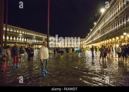 Inondations dans la place Saint-Marc, Venise, Italie. Les gens patauger dans l'inondation dans la nuit. Banque D'Images