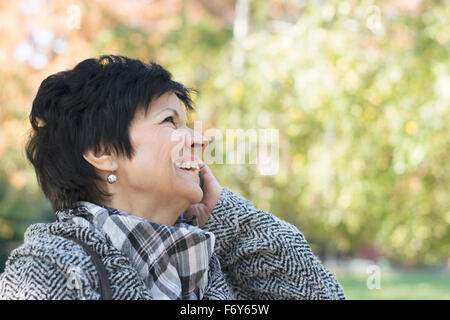 Belle femme d'âge moyen avec l'utilisation de la coupe sombre court in park Banque D'Images