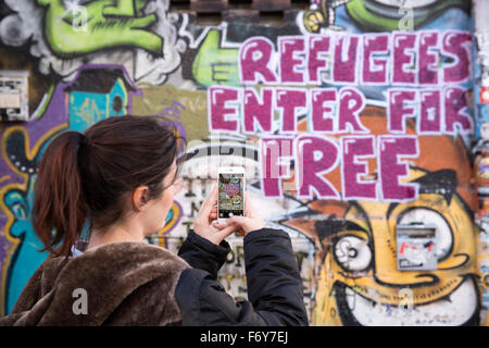 Femme prendre une photo d'un graffiti sur un mur d'une auberge en Allemagne Banque D'Images