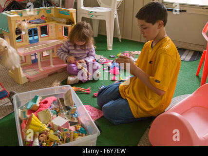 Petite fille et garçon jouant avec des poupées. Soeur et frère. Banque D'Images