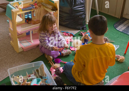 Petite fille et garçon jouant avec des poupées. Soeur et frère. Banque D'Images