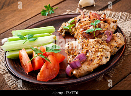 Fillet de porc grillée avec des légumes sur la plaque en céramique Brown. Banque D'Images