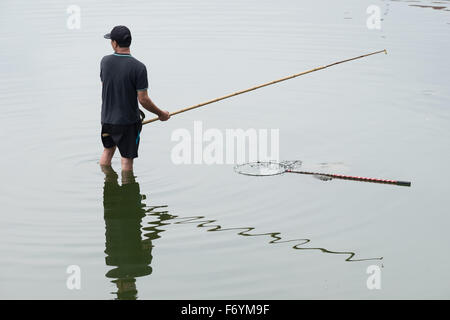 Un homme à la pêche dans le lac de l'Ouest dans la ville capitale du Vietnam - Hanoï Banque D'Images