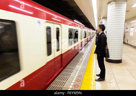 Un homme japonais en attente dans le métro pour un train qui passe Banque D'Images