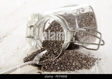 Semences chia dans un récipient en verre et cuillère Banque D'Images