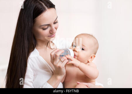 Heureuse mère nourrit son bébé bouteille Banque D'Images