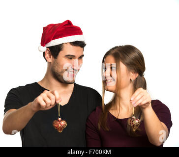 Jeune couple, homme et femme, souriant, heureux, portant des décorations de Noël, la tenue de nouvelles années toys Banque D'Images