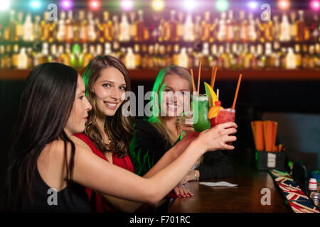 Groupe d'amis au bar élever leur verre de cocktals Banque D'Images