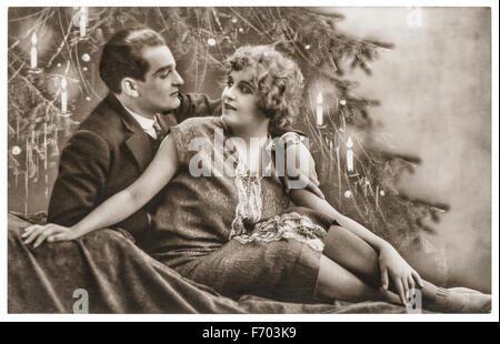 L'homme et de la femme dans l'amour célébré avec l'arbre de Noël. Centemental romantique vintage Photo avec grain de film original et flou Banque D'Images