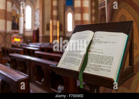 Bible ouverte sur le stand à l'intérieur de la cathédrale San Lorenzo (alias Duomo) à Alba, Italie. Banque D'Images