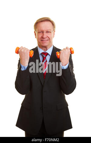 Senior businessman exerçant avec deux haltères orange Banque D'Images