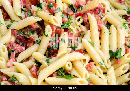 La cuisine italienne : pâtes appelées pennette mezze avec tomates en morceaux et la roquette. L'échantillon de texture Banque D'Images