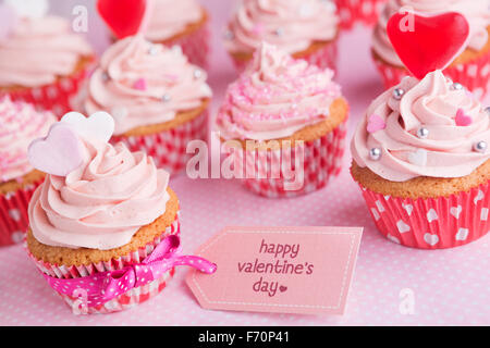 Valentine rose cupcakes avec les mots "Happy Valentine's day' sur une étiquette. Banque D'Images