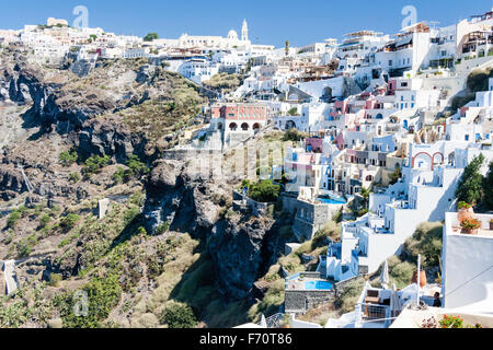 Santorin, Fira. Voir l'établissement ainsi que des terrasses construites sur la falaise sur le bord de la caldeira. La plupart des bâtiments blanc lavé. Ciel bleu clair. Banque D'Images