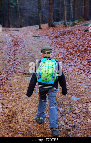 Portrait d'un garçon à l'extérieur de marche dans une forêt - se promener le long du chemin de la forêt d'automne Banque D'Images