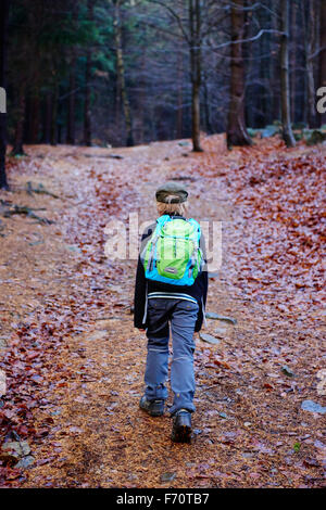 Portrait d'un garçon à l'extérieur de marche dans une forêt - se promener le long du chemin de la forêt d'automne Banque D'Images