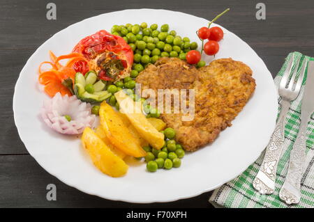 Steak avec pommes de terre en forme de coeur, les tomates cerises et les haricots verts sur une plaque Banque D'Images