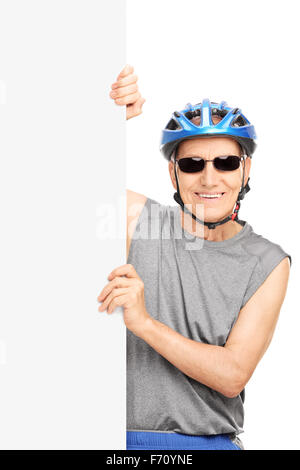 Shot vertical d'un cycliste avec lunettes posant derrière un panneau blanc isolé sur fond blanc Banque D'Images