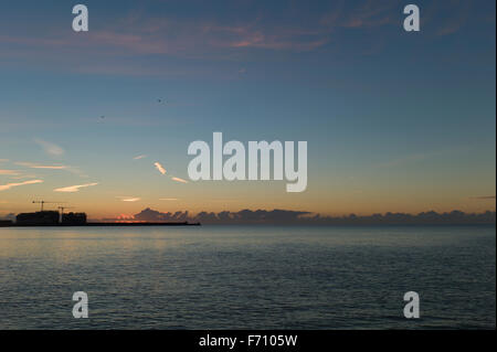 Le lever du soleil sur le port de plaisance de Brighton mur du port. Banque D'Images