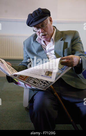 Homme lisant un journal dans l'attente d'un train, Banque D'Images