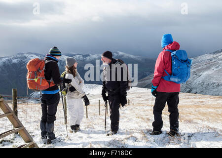 Les gens les randonneurs randonnée dans la neige sur la montagne au-dessus de Goch Foel Llanberis Pass dans le parc national de Snowdonia en hiver. Le Nord du Pays de Galles Royaume-uni Grande-Bretagne Banque D'Images