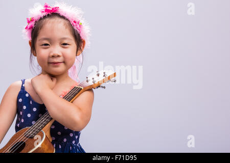 Petite fille avec son ukulélé, instrument de musique à cordes. Banque D'Images