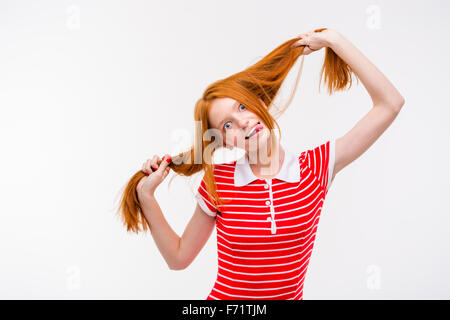 Rousse amusant drôle positive woman langue et s'amusant posant sur fond blanc Banque D'Images