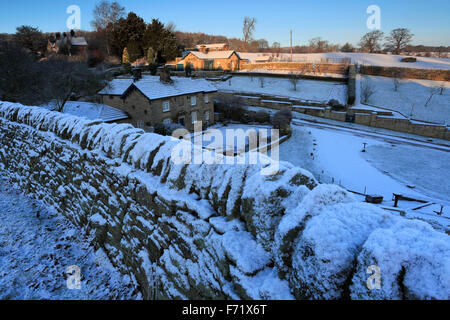 Neige de l'hiver Janvier, cottages à Rendeux village ; de Chatsworth, Derbyshire ; parc national de Peak District, l'Angleterre, Royaume-Uni Banque D'Images