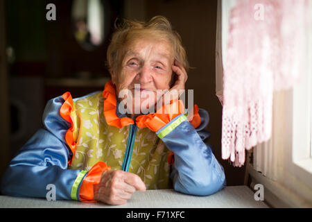 Une femme âgée en vêtements cosaque, un portrait par la fenêtre. Banque D'Images