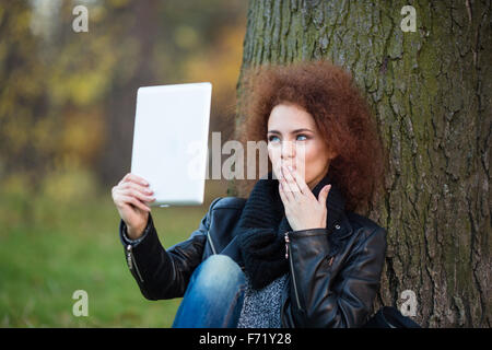 Portrait d'une jeune femme faisant photo selfies sur ordinateur tablette ou en faisant appel à l'extérieur vidéo Banque D'Images