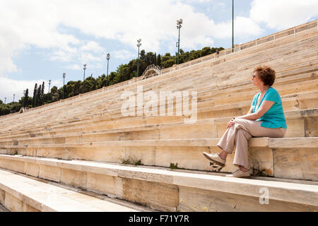 Tourist assis sur des sièges dans le Stade Panathénaïque, stade olympique moderne de jour d'origine, Athènes, Grèce Banque D'Images