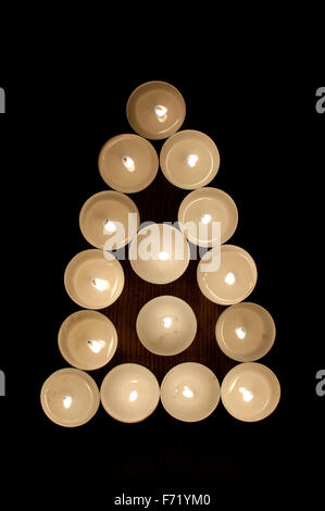 Lumières de thé disposées en forme de triangle et un arbre Banque D'Images
