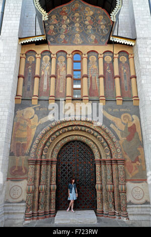 Une femme debout devant l'entrée de côté porte de la cathédrale de l'Assomption au Kremlin, Moscou, Russie. Banque D'Images