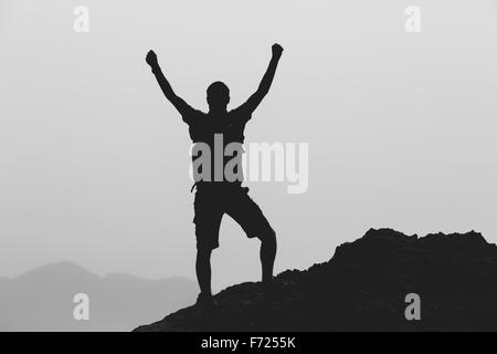 Réalisation Succès L'escalade ou la randonnée réalisation concept d'affaires avec l'homme de célébrer avec les bras, soulevé tendus. Banque D'Images