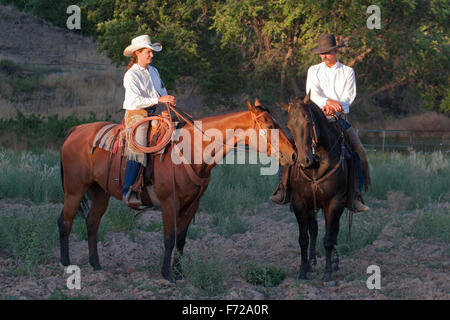 Cowgirl et cowboy à cheval sur un ranch au Nouveau-Mexique Banque D'Images