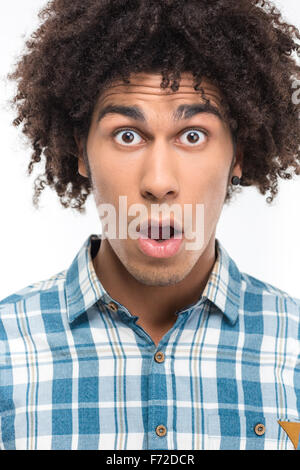 Portrait d'un homme choqué avec les cheveux bouclés à la caméra à l'isolé sur fond blanc Banque D'Images